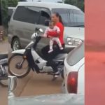 Mulher carrega bebê na moto, pilotando com uma só ...